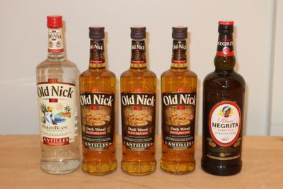 quatre bouteilles d'alcool sont alignées sur une table en bois