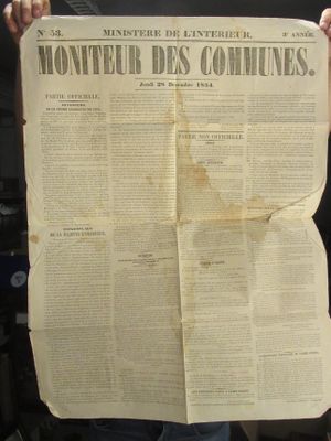 quelqu'un tient un journal sur lequel est posé une très grande feuille de papier