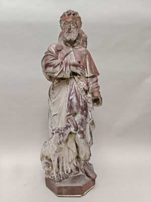 une vieille statue représentant un homme tenant un chien, sur fond blanc