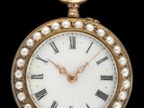 une montre de poche ancienne en or, avec des chiffres romains et des perles