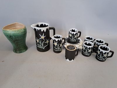 a lot of black and white vases and cups on the table