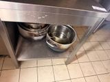 two pots and pans sitting on a stainless steel table