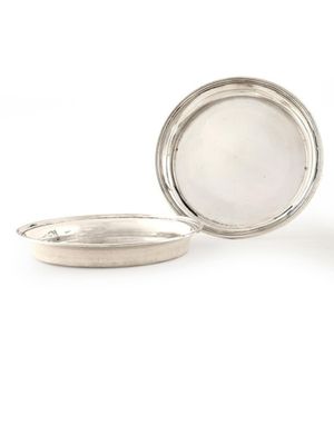 un récipient en argent muni d'un couvercle en argent, posé sur une surface blanche