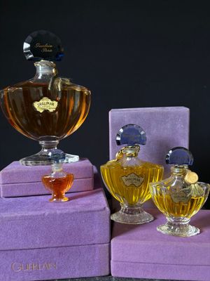 purple boxes with perfume bottles sitting on top of them on a table