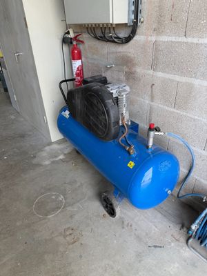 a blue air compressor sitting next to a fire hydrant
