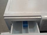 a white refrigerator with a drawer inside of it