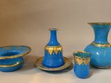 a group of blue and gold vases and bowls on a table