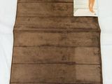 an image of a brown blanket on a bed with a tag on it