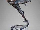 une sculpture en bronze représentant une femme assise sur un tabouret