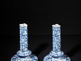 two blue and white candlesticks on a black surface