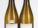 deux bouteilles de vin posées l'une à côté de l'autre sur une surface blanche