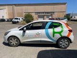 a small white car parked in front of a building