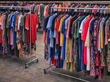 beaucoup de vêtements suspendus à une étagère dans un magasin