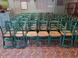 rows of green chairs in a room with a brick floor