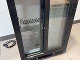 an image of a glass door refrigerator in a kitchen