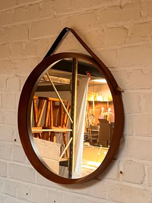 un miroir accroché à un mur de briques dans une pièce