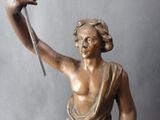a bronze statue of a woman holding a bird in her hand