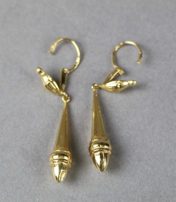 pair of gold plated earrings on a grey surface