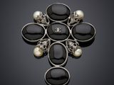 une broche en noir et blanc ornée de perles sur fond noir