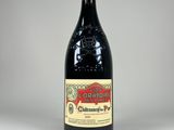 une bouteille de vin rouge posée sur une table blanche