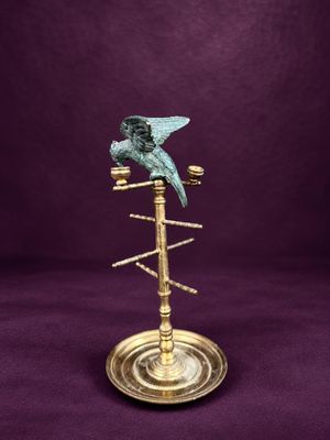 un oiseau sur une plaque en laiton avec un fond violet