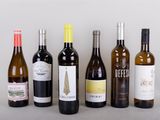 several bottles of wine are lined up on a table