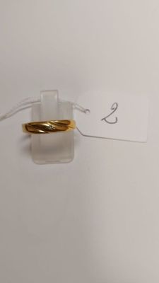 a gold ring on top of a clear piece of paper