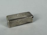 a small silver box sitting on a white surface