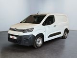 La camionnette blanche est garée dans une pièce au sol gris