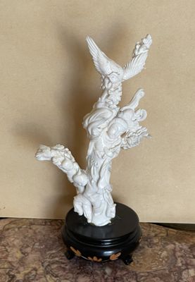 une statue représentant un oiseau, posée sur un socle posé sur une table