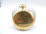a gold pocket watch sitting on a white table