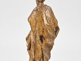a bronze statue of a woman in a robe and hat