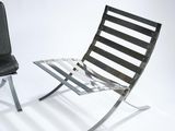 pair of black leather lounge chairs against a white backdrop