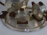 two silver teapots on a silver tray on a table