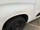 a close up of a white truck with a flat tire
