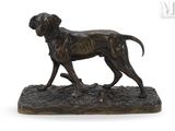 bronze statue of a dog standing on a rock on a white background