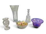 three vases and a bowl of flowers on a white surface