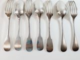 a lot of silver spoons and forks on a table