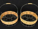 pair of woven baskets with handles on a black background