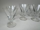 several empty wine glasses are lined up on a white surface