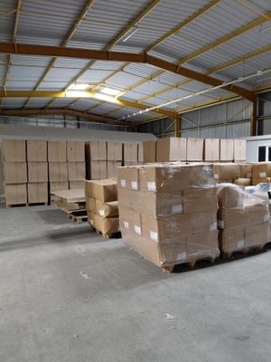 un grand entrepôt rempli de cartons et de palettes