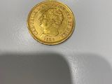 gros plan d'une pièce d'or sur une surface blanche