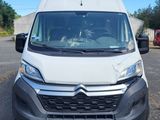 the front of a white van parked in a parking lot