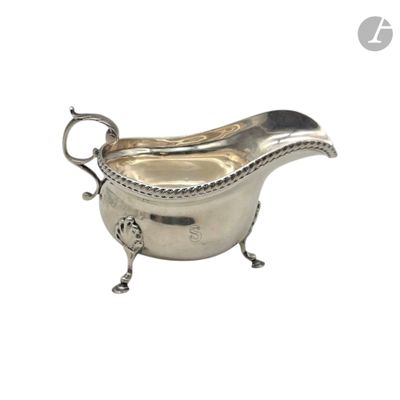 an antique silver gravy with rope handles on a stand