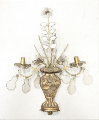une applique murale sur laquelle est représenté un vase avec des fleurs