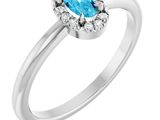 une bague ornée d'une topaze bleue ovale et d'une topaze blanche, sertie de diamants