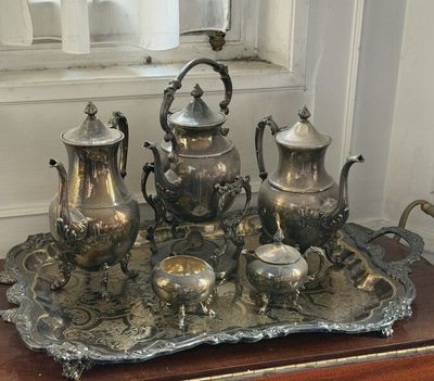 a silver tray with a silver tea set on top of it