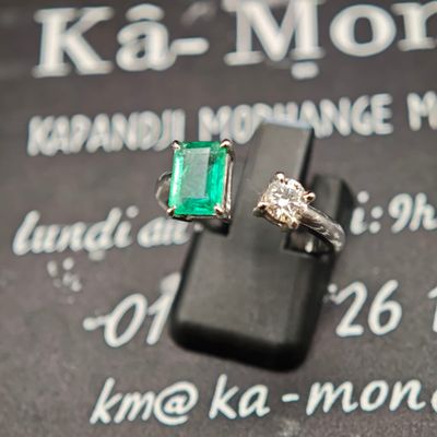 une bague ornée d'une pierre verte posée sur un panneau