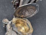 a silver object with a knife in it on a table