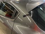 a silver car parked in a showroom with its door open
